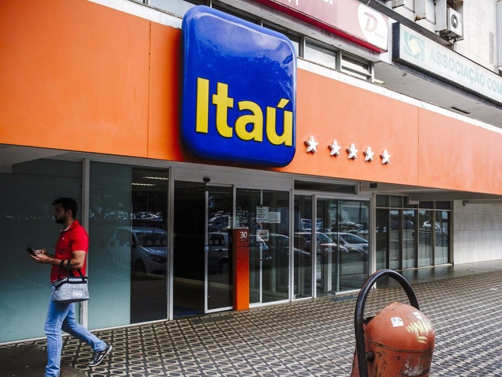 A pedestrian passes in front of a Itau Unibanco Holding SA bank branch in Brasilia, Brazil, on Friday, Jan. 20, 2017. Itau, the biggest bank in Latin America by market value, has reached an agreement to postpone to January 2022 the acquisition of shares of Colombia's CorpBanca. Photographer: Gustavo Gomes/Bloomberg